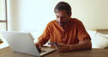 Olgun bir adamın çevrimiçi satın alımı, güvenli e-banka sistemi üzerinden kart ödeme faturalarına girer, kolay ve hızlı para transferi sitelerini kullanarak, malları uzaktan sipariş ederek. Elektronik ticaret müşterisi e-alışveriş yapıyor