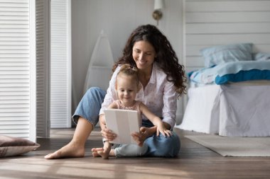 30 'lu yılların İspanyol annesi sıcak yatak odasında küçük kızıyla birlikte oturuyor, dijital tableti tutuyor, çizgi filmlerden ya da yeni oyundan zevk alıyor, birlikte eğitim videosu izliyor, video görüşmesi yapıyor, çevrimiçi öğreniyor. Çocuk gelişimi