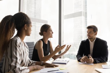 Çok ırklı bir iş grubunun başlangıç stratejisi üzerine beyin fırtınası yapması, takım çalışması tartışması, proje yönetimi planlaması. Pozitif bayan yönetici iş arkadaşları ve patronla toplantıda konuşuyor.