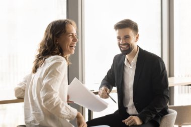 Neşeli ofis arkadaşları proje üzerinde beyin fırtınası yapıyorlar, yaratıcı fikirleri birlikte tartışıyorlar, gülüyorlar, eğleniyorlar, başka yere bakıyorlar, iş molası veriyorlar, iletişim kuruyorlar.