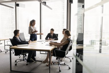 Çağdaş şehir içi ofislerinde çeşitli bin yıllık iş adamları büyük masada toplanıyor. Afrikalı proje yöneticisi fikirler, takım çalışması planı sunuyor, iş arkadaşlarıyla konuşuyor