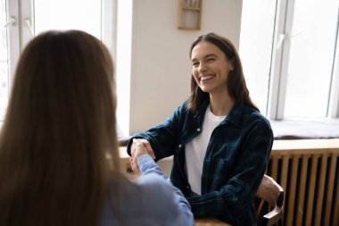 Neşeli genç müşteri kadın, bayan temsilciyle selamlaşıyor, satış müdürüne teşekkür ediyor. Mutlu iş arkadaşları iş çıkışı el sıkışıyor, gülümsüyor, gülüyorlar.