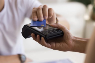 Customer man making payment for service, purchase, cashless technology, bank service, applying credit plastic card to terminal screen. Hand of shopper, buyer, seller close up cropped shot clipart