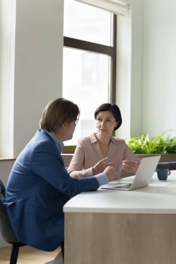 Bir çift orta yaşlı iş arkadaşı iş yerinde buluşuyor, laptopta konuşuyor, iş meselelerini tartışıyorlar. Kendinden emin, olgun bir iş kadını erkek meslektaşına proje stratejisini açıklıyor. Dikey çekim