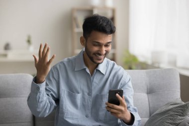 Neşeli, heyecanlı, genç Hintli, serbest çalışan, cep telefonu tutan, ekrana bakan, kazanan eli yapan, başarıyı kutlayan, başarı, galibiyet, sonuç, gülümseyen,