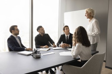 Olgun şirket akıl hocası, antrenör çalışanları danışmanlık, tavsiye. Toplantı masasında oturan, oturan, genç meslektaşlarını dinleyen bir iş adamı.