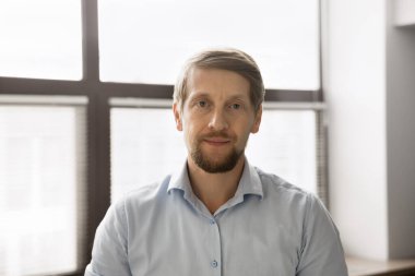 Ciddi sarışın, orta yaşlı iş adamı. Soluk mavi gömlekli, kameraya bakıyor. İş adamı, girişimci, şirket sahibi, yönetmen portresi