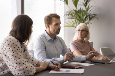 Meslektaşlarıyla, proje ortaklarıyla konuşan ciddi genç iş adamları, çeşitli takımlarla görüşen iş adayları, geniş bir masada oturan, iş arkadaşlarıyla konuşan,