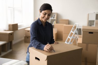 Positif güzel Hintli mağaza müdürü gönderme, yazma, paketlenmiş karton kutu üzerinde adres gönderme, gülümseme, gülme, iş süreci için satın almaya hazırlanıyor