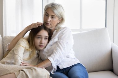 Şefkatli büyükanne üzgün ergen torun kızını teselli ediyor, çocuğa sevgiyle sarılıyor, ona destek oluyor, aile desteği veriyor, empati kuruyor, çocukla konuşuyor, sorunları tartışıyor, depresyonu tartışıyor.