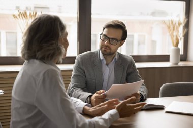 Yakışıklı genç bir erkek işveren iş görüşmesinde kadın profesyonel adayla konuşuyor, özgeçmişi tartışıyorlar. Patron ve müdür çalışma planı, strateji ve satış raporlarını toplantı masasında tartışıyor.