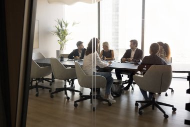 Çeşitli bin yıllık iş ortakları takımı modern ofis toplantı odasının içinde anlaşmayı tartışıyor. Bir grup profesyonel, işbirliğini tartışan girişimciler. Cam manzaralı.