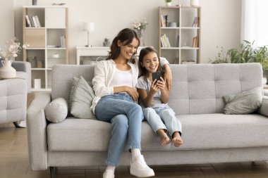 Mutlu bir anne ve neşeli bir kız çocuğu internet üzerinden iletişim, boş zaman, eğlence, aile selfie 'si, görüntülü konuşma için cep telefonu uygulaması kullanıyor.