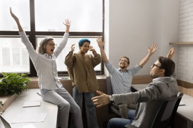 Neşeli, farklı, farklı, farklı yaşlardaki farklı iş adamları başarıyı, iyi haberleri kutluyor, sevinç çığlığıyla el kaldırıyor, gülüyor, takım çalışması satışlarından keyif alıyor, başarılı bir işbirliği yapıyor.