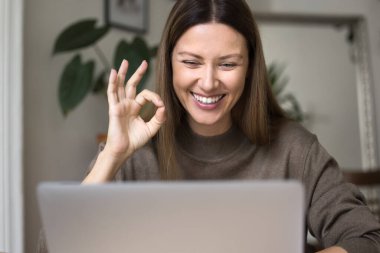 Neşeli serbest çalışan iş kadını dizüstü bilgisayarda el hareketi yapıyor, video görüşmesinde konuşuyor, gülümsüyor, gülüyor, online iş projesi üzerinde çalışıyor, İnternet 'te tabela iletişiminden keyif alıyor.