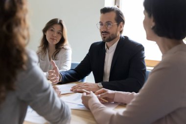 Kendine güveni olan yakışıklı işadamı ortaklarla toplantı, anlaşma ve konferans masasında anlaşmaya varma projesini anlatıyor. İşveren iş görüşmesi adayı