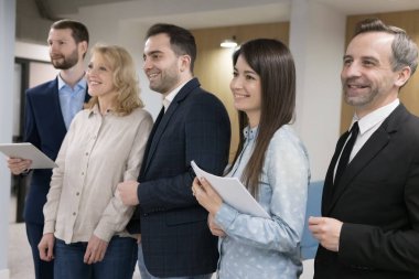 Farklı yaşlardaki farklı iş arkadaşlarıyla dolu neşeli bir ekip ofiste yan yana duruyor, kameraya bakıyor, gülümsüyor, gülüyor. Olgun akıl hocası, patron, lider ve olumlu çalışan portresi