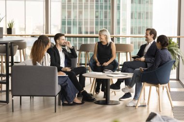 Modern ofis lobisinde daireler çizen mutlu iş adamları. Çağdaş çalışma alanı. Takım çalışması stratejisi, işbirliği, gülümseme, gülme, muhabbet.