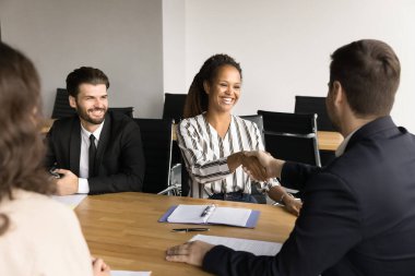 Erkek patron en iyi yönetici kadınla tokalaşıyor, proje başarısını çoklu etnik gruplarla tartışıyor, işbirliği, yardım, ortak, müşteri, yatırımcı ile anlaşmaya vardığı için ortaklara teşekkür ediyor.