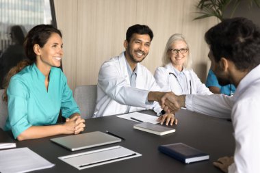 Kendine güvenen başhekim ortaklar, sponsorlar ve iş görüşmelerinden sonra yeni bir doktor işe alıyor. Mutlu iyileşmiş bir hasta şükranla selamlıyor.