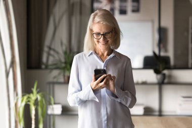 İnternet uygulamasını, servisi, cep telefonundaki sanal asistanı kullanan neşeli sarışın iş kadını. Sadece ofis ortamında dijital teknolojiyle eğleniyor.
