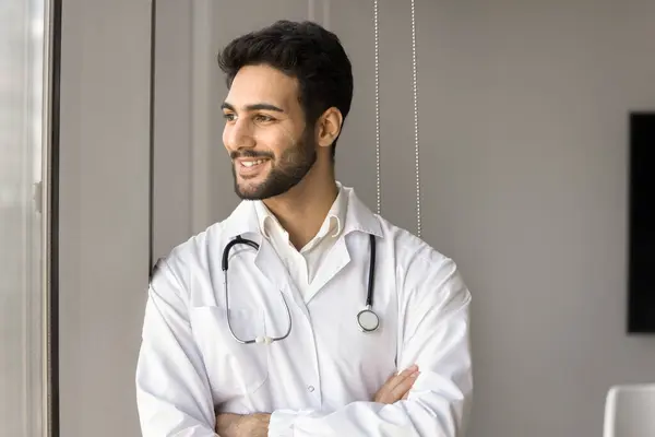 Positive Successful Arab Doctor Man Standing Window Hands Crossed Looking Royaltyfrie stock-fotos