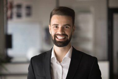 Resmi takım elbiseli mutlu yakışıklı iş adamı dişlek gülümsemesiyle kameraya bakıyor, gülüyor. İş adamı, şirket yöneticisi, profesyonel vesikalık, video görüntüsü.