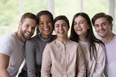 Çok ırklı mutlu öğrenciler, stajyerler, birbirine yakın poz veren arkadaşlar, dişlek tebessümle kameraya bakmak, gülmek, toplantı yapmak, sosyal iletişim, grup başarısı.