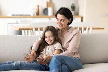 Çekici ve yaşlı bir kadın anaokulu torunu ile vakit geçirir kanepeye oturur keyifli bir iletişimin, anlayışın ve onların ahenkli ilişkilerinin tadını çıkarır. Çok nesilli aile bağları, velayet