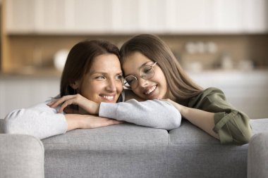 Mutlu rüyalar anne ve genç kız rahat ev koltuğunda dinleniyor, sarılıyor, konuşuyor, gülüyor, gülüyor, aile planlarını tartışıyor, birlikte hayal kuruyor, gözlerini kaçırıyor.