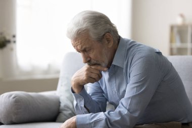 Üzgün, yalnız, gri saçlı, yaşlı bir adam, yaşlılık sorunları hakkında düşünüyor, evde sıkılıyor, hasta, yorgun, depresyonda, hafıza kaybı, zihinsel bozukluk yaşıyor.