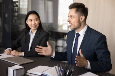 Ekip beyin fırtınası için fikir öneren, toplantı masasında iş arkadaşlarıyla konuşan, pazarlama planını açıklayan yaratıcı bir iş adamı. Çeşitli iş grupları birlikte çalışıyor.