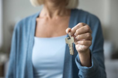 Bilinmeyen yetişkin kadın emlakçının kameraya birkaç anahtar göstermesi müşteriye karlı bir teklif yapması ya da kısa kiralı daire tutması. Gayrimenkul alımı, yeni mülkiyet, taşınma, hizmetler