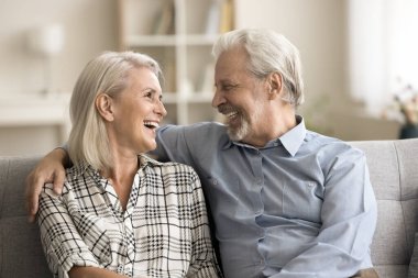 Mutlu, emekli koca ve eş sıcakkanlılıkla, sevgiyle sarılıyor, kanepeye yakın oturuyor, konuşuyor, gülüyor, eğleniyor, evlilikten zevk alıyor, ilişki, arkadaşlık