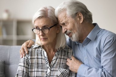 Suçlu koca, olgun, kırgın karısından özür dileyip af diliyor. Sevgi dolu kıdemli bir adam üzgün yaşlı bir kadına destek olur, destek olur ve sarılır.