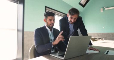 İki çok ırklı yetişkin erkek iş arkadaşı, ofiste buluştular, dizüstü bilgisayar kullandılar, pazar araştırması yaptılar, pazarlama stratejisi planladılar, başlamaya hazırlandılar, finansal analiz yaptılar. Ticaret, proje yönetimi