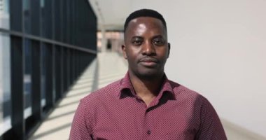 Koridorda durup kameraya bakan başarılı Afrikalı iş adamının kafa resmi. Erkek şirket patronunun portresi, başvuru sahibi ya da İK yöneticisi. Profesyonel başarı, kariyer ve terfi