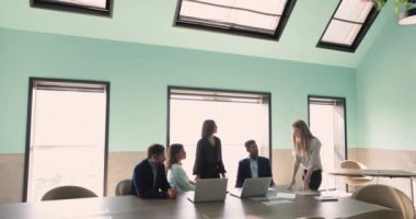 Genç iş kadını, kadın eğitmen konuşma yapıyor, kurum personeliyle toplantı odasında brifing veya eğitim sırasında rapor veriyor, görüş ve bilgileri paylaşıyor, iş vizyonu ve çözümleri ifade ediyor