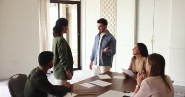 Şirket lideri genç bir çalışanın elini sıktı, yaptığı iş için övgü topladı, iyi iş çıkardığı için teşekkür etti, çeşitli personel üyeleriyle brifingde harika bir sonuç elde etti, başarılı ve yetenekli takım arkadaşını tebrik etti.