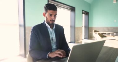 Ciddi odaklı Hintli işadamı fikirleri gözden geçirir, düzeltmeler yapar, yeni yazılımlar öğrenir, çevrimiçi belgelere bakar, bilgisayarla çalışır, şaşkın, endişeli hisseder, arama sorunları çözümü