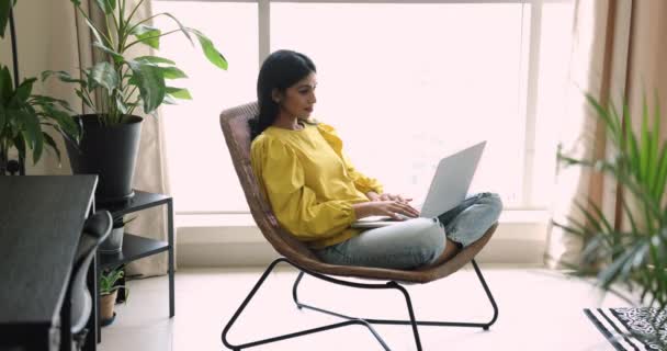 Hübsche Inderin Die Laptop Arbeitet Sitzt Einem Modernen Sessel Wohnzimmer — Stockvideo