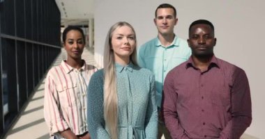 Profesyonel personelin portresi, modern ofis koridorlarında kameraya poz veren dört genç çoklu etnik çalışan. Promosyon, işe alım, insan kaynakları, başarılar ve kariyer büyümesi