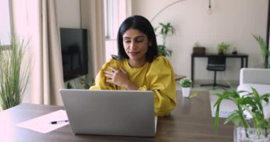 Çekici gülümseyen Hintli kadın ev ofisinden uzak bir iş yapıyor, web sayfasında sörf yapıyor, internette bilgi topluyor. Kadın bağımsız baş yazışmalar, e-posta yoluyla müşteriye cevap. İş, teknoloji