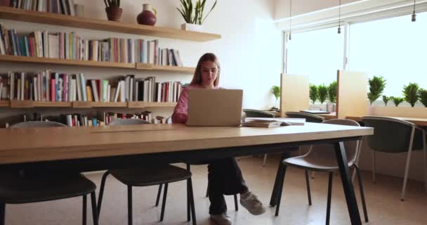 Fokuserad Kaukasisk Kvinnlig Student Skriver Uppsats Med Hjälp Laptop Arbetar — Stockvideo