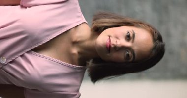 İçerde dikilen, gülümseyen ve kameraya bakan gündelik elbiseli mutlu genç bir kadın. Profesyonel öğretmen portresi, kiracı, bin yıllık kadın, iyimser ruh hali ve bağımsızlık