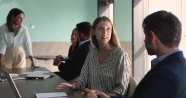 Genç 25 'li yaşlarda İspanyol bir kadın şirket çalışanı erkek meslektaşıyla konuşuyor, düşüncelerini, çözümünü ve vizyonunu paylaşıyor, yeni görev ya da amacını çalışma arkadaşına anlatıyor, modern ofiste buluşan proje üzerinde çalışıyor.