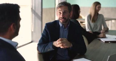 Çok ırklı iki yetişkin iş ortağı, ofiste yapılan görüşmeler sonrasında el sıkışıyor, saygı gösteriyor, el sıkışarak işbirliği yapıyor, karlı bir anlaşma yapıyor, iş adabını uyguluyor.