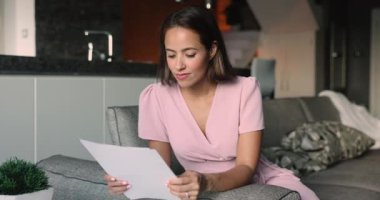 Kadın kanepeye oturup kağıt döküman okuyor, iyi haberler öğreniyor, inanılmaz bir teklif alıyor, fantastik işler alıyor ya da okuma fırsatı buluyor, sevinçten çığlık atıyor, heyecanlı görünüyor. Başarı, başarı