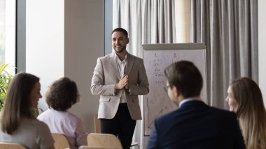 Erkek işletme eğitmeni, profesyonel antrenör ters çizelge sunumu yapar, grup eğitimi sırasında müşterilere danışmanlık yapar veya çalışanlara öğretmenlik yapar, pazarlama stratejisini açıklar, bilgi sağlar. Seminer