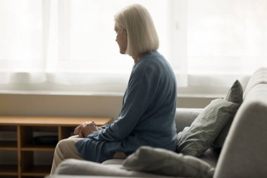 Evde, koltukta oturan yalnız, yaşlı bir kadın kendini kaybolmuş, depresyonda, stresli, ilgisiz, sağlık sorunları, kayıp, keder, hafıza kaybından muzdarip, sorunlar üzerinde düşünüyor.